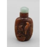 Chinese snuff bottle. Quartzite of rounded rectangular form, carved in high relief using lighter