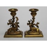 A pair of 19th century cast ormolu dwrf candlesticks, modelled as a recumbent stag and doe beside