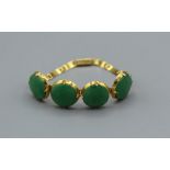 An antique Apple Jade (Jadeite) bracelet in yellow metal. The jade comprises four cabochons of a