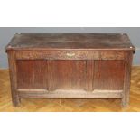 An 18th century oak coffer, the plank top with later hinges, over a scroll carved frieze and three