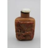 Chinese snuff bottle. Quartzite of flattened rounded rectangular form, carved in high relief with