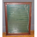 An Edwardian oak wall mounting display case/collectors cabinet with glazed door enclosing a green