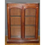 A Victorian mahogany floorstanding bookcase, the moulded cornice over a pair of arched glazed
