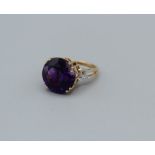 An 18k Gemporia amethyst and diamond ring, the round amethyst of 11.35ct, with diamond set pierced