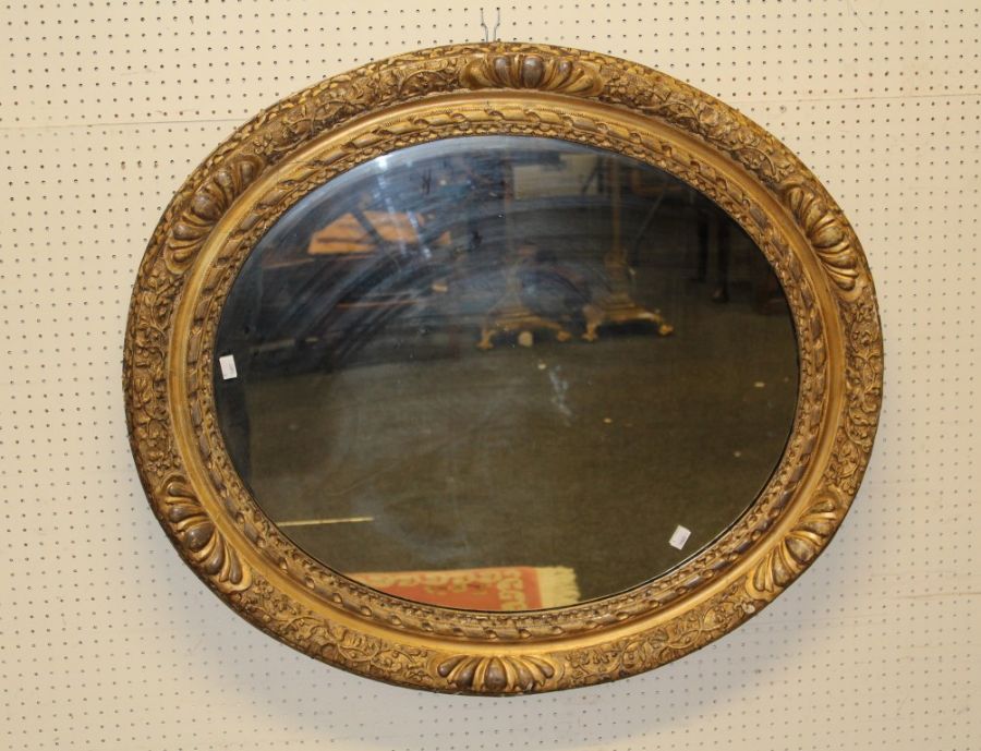 A large 19th century gilt gesso oval portrait picture frame with moulded floral decoration,