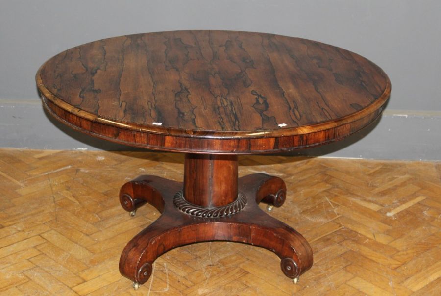 An early 19th century Rosewood breakfast table, the circular tilt top on a stout column with