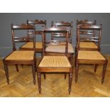 A set of six George IV mahogany dining chairs, the unusual backs above carved seats with squab
