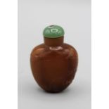 Chinese snuff bottle. Quartzite of rounded shield form, carved in low relief with an overall
