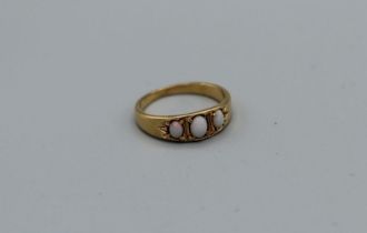 An opal three stone ring in yellow metal, assessed as gold, size N, approximately 3.5gm weight