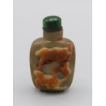 Chinese snuff bottle. Quartzite of rounded rectangular form on raised foot, carved in high relief