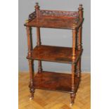 A Victorian walnut whatnot, the three tiers raised on turned legs and castors, W53cm