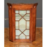 A 19th century satinwood, mahogany banded and ebony strung wall mounting corner cupboard, the dentil