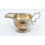 A George V silver large sauceboat, wavy border on stepped oval foot, hallmarked London 1925,