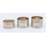 Three various 20th Century silver engine turned napkin rings, various dates and makers, approx 4.