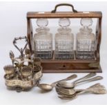 An early 20th Century oak brass bound tantalus with three glass spirit decantes together with plated