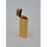 A Cartier gold plated cigarette lighter, in very good condition, appears little used/unused.