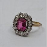 A precious yellow metal, diamond and ruby cluster ring, set oval mixed cut ruby to centre (ERW 1.5