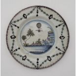 An 18th century English Defltware plate, the rim with manganese glaze, painted in colours, the