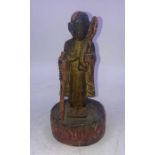 A Japanese carved wooden figure of a traveling monk. H:19cm