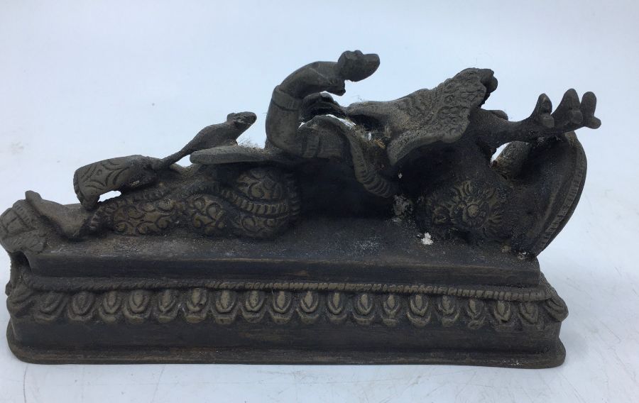 A 20th century Indian bronze figure of reclining four armed Ganesha, length 17.5cm. - Image 3 of 4