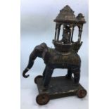A 20th century Indian Wooden figure of an elephant and rider, black paited with gilt decoration,