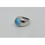 A 14ct. white gold and blue topaz ring, bezel set light blue topaz cabochon. (9.6g). Size approx. UK