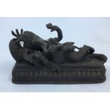 A 20th century Indian bronze figure of reclining four armed Ganesha, length 17.5cm.