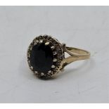 A 9ct. gold, sapphire and diamond ring, set oval mixed cut sapphire to centre bordered by numerous
