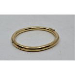 A 9ct. gold hinged eliptical bangle, interior dimensions aprrox. 62mm x 50mm. (12.7g)
