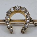 A precious yellow metal and diamond horsehoe brooch, set thirteen graduated old-cut diamonds (ETDW