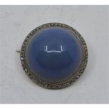 A precious white metal, diamond and blue cabochon stone set circular brooch, (white metal assessed