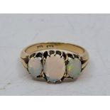 An 18ct. gold three stone opal ring, set three graduated oval cabochon opals, (gross weight 3.6g,