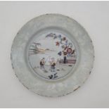 A mid 18th century English Delftware plate, painted bianco-sopra-bianco to rim and in colours to