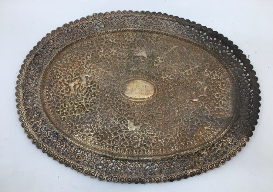 An early 20th century Indian white metal presentation oval plate, repousse scrolling foliage and