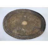 An early 20th century Indian white metal presentation oval plate, repousse scrolling foliage and