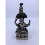 A 20th century Sino-Tibetan white metal figure of a seated four armed deity, height 19.2cm