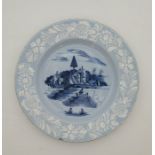 A mid 18th century English Delftware plate, the rim decorated bianco-sopra-bianco, to pale blue