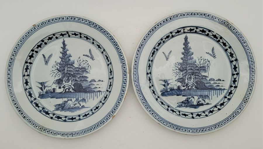 A pair of 18th century Delftware plates, painted in blue, diameter 23.2cm. (2) Condition note: