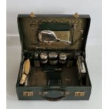 A Mappin & Webb Ltd ladies' green leather vanity case, containing a silver mounted bevel plated hand