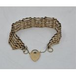 A 9ct. gold gate bracelet with heart padlock clasp, width 20mm x length 18cm. (12.2g)