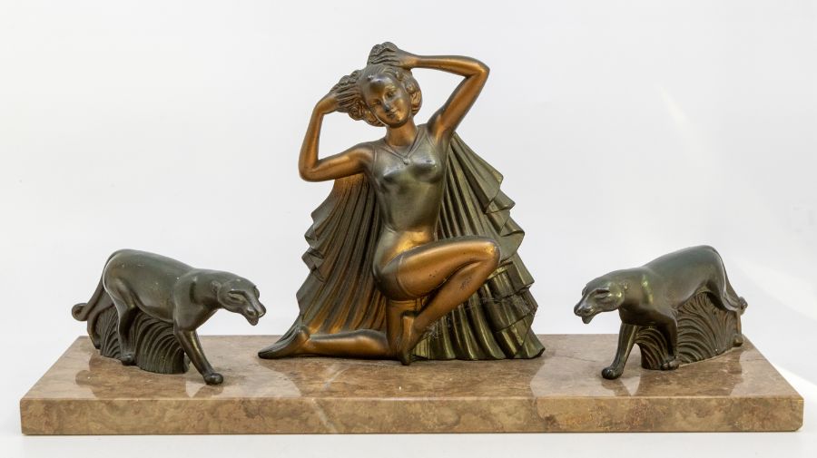 An Art Deco spelter sculpture of a lady in stylised pose, with panthers either side, on a marble