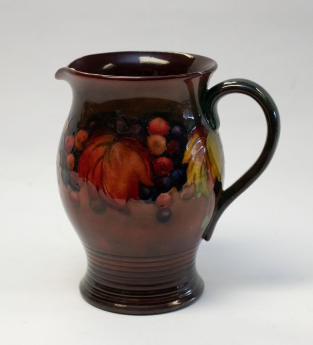 William Moorcroft, a Flambe Leaf and Berry jug, circa 1935, flared barrel form, with ribbed foot, - Image 2 of 3