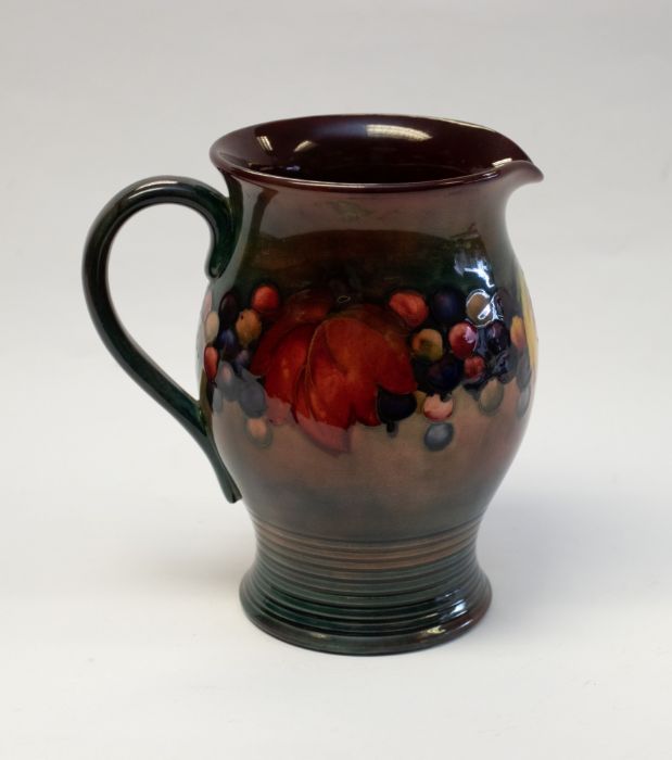 William Moorcroft, a Flambe Leaf and Berry jug, circa 1935, flared barrel form, with ribbed foot,