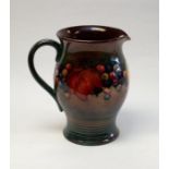 William Moorcroft, a Flambe Leaf and Berry jug, circa 1935, flared barrel form, with ribbed foot,