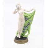 Goldschneider figurine of female with a green floral decorated drape to rear, on gilt metal base.