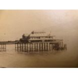 Photograph mounted on card of a seaside resort, pier and beach