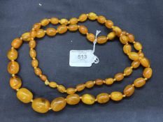 Jewellery: Necklet of (57) graduated oval amber beads, size of beads 26mm. x 19.8mm. to 10.8mm. x