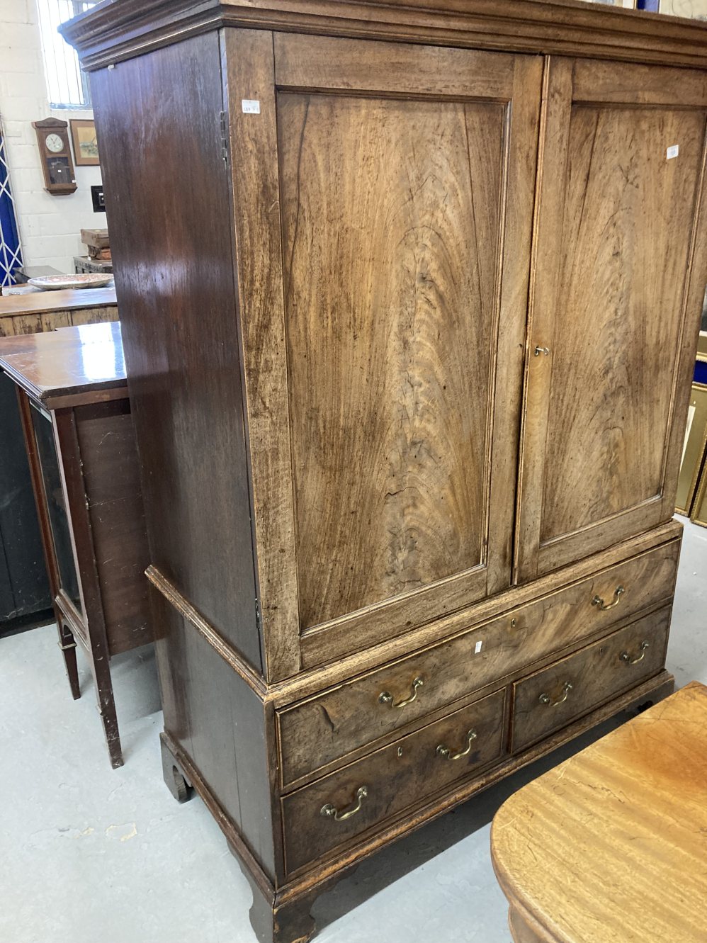 19th cent. Mahogany linen press with five sliders above one long and two short drawers on bracket