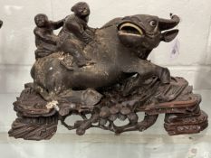 20th cent. Chinese hardwood carved water buffalo with two boys on its back, on stand. 1 horn A/F.