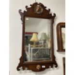 Early 19th cent. Mahogany mirror, shaped top with carved gilded ha ha bird and shaped bottom with